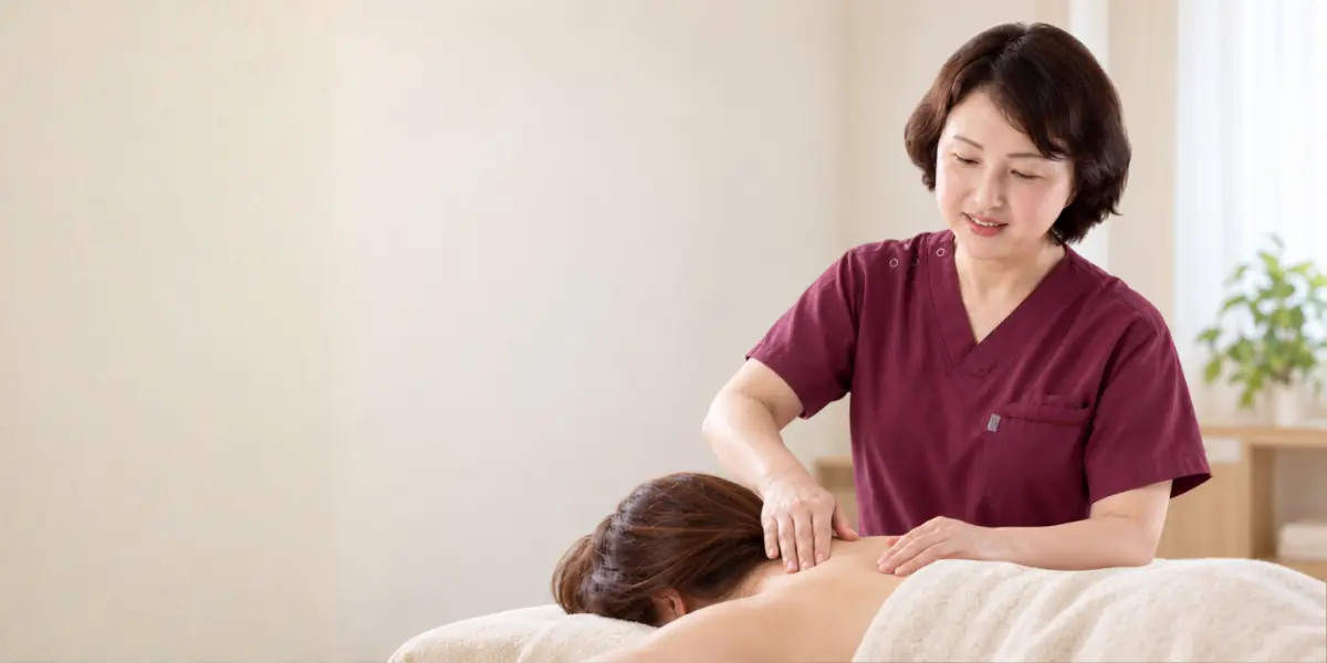 女性の肩まわりに手を添え、体の状態を確認する施術イメージ