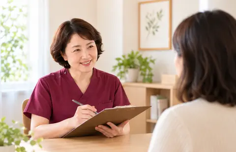 女性患者の話を聞きながら問診する鍼灸師