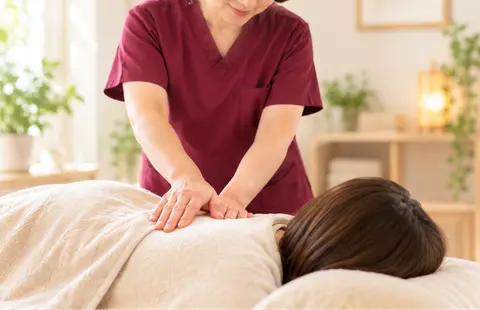 女性患者の背中の状態を確認しながら施術する様子